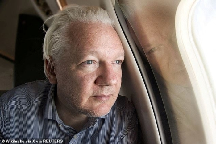Julian Assange looks out of a plane window today as he prepares to arrive in Bangkok, Thailand, following his release from a British prison